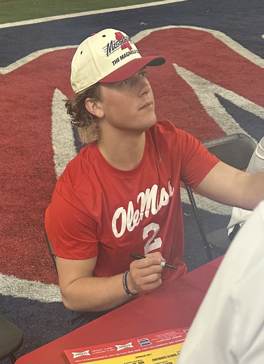 Former Ole Miss quarterback Jaxson Dart signs autographs after the April 2024 spring game. Archival photograph; Dart is not presented as a participant in this matchup.